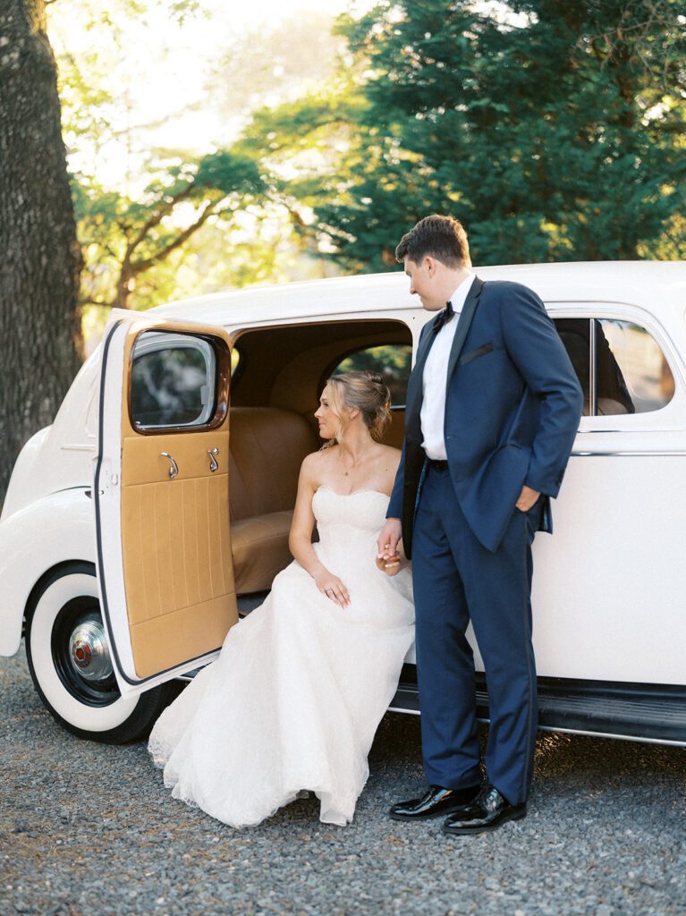 Couple posing with a classic vintage car at Whitehead Manor in Charlotte, NC